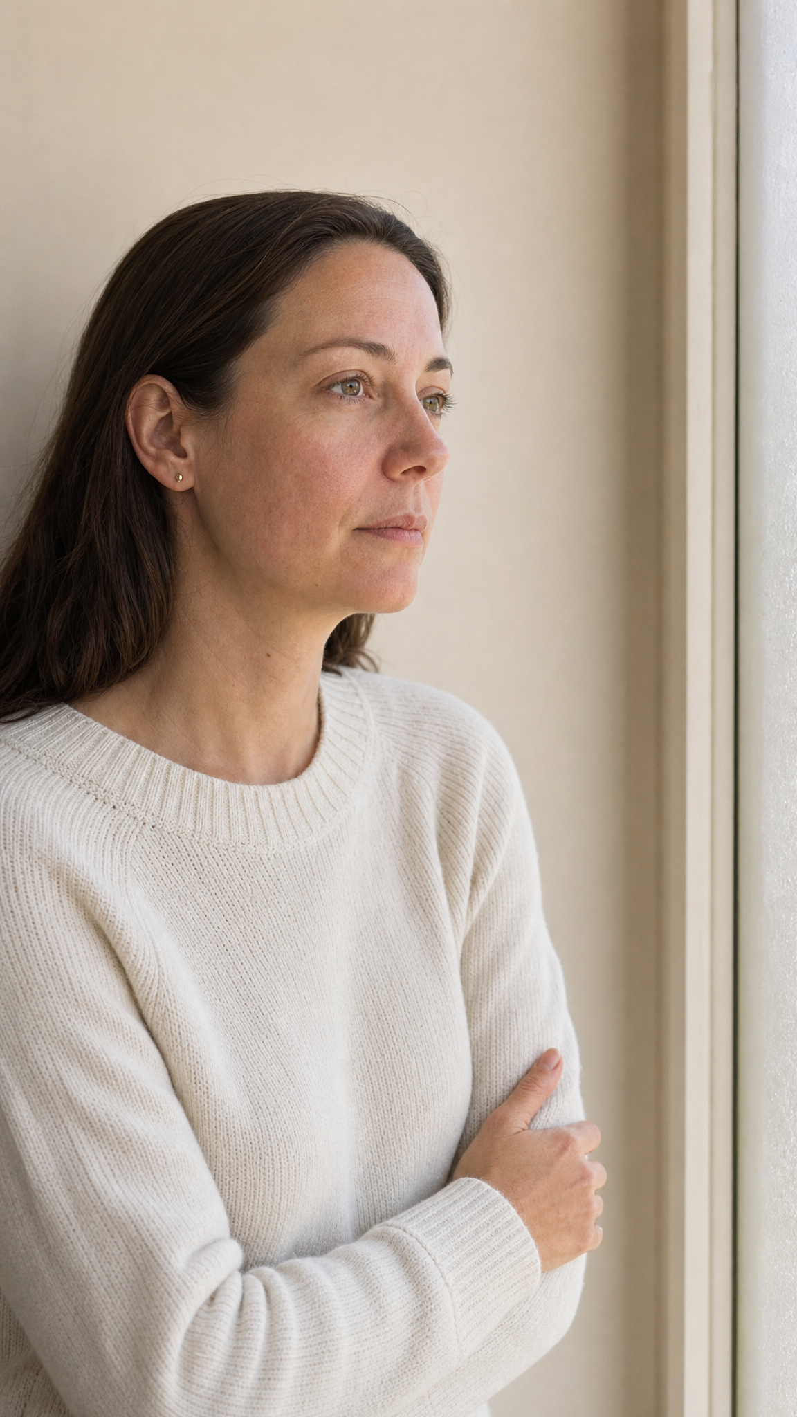 Calm editorial portrait of an adult with natural skin texture, shown against a warm ivory background with subtle annotations indicating facial proportions, features and movement.